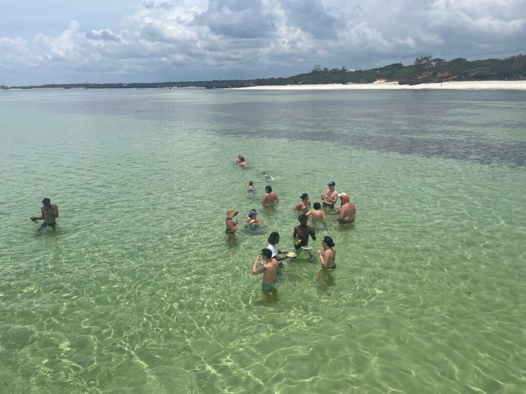 Turyści kąpiący się w płytkiej, turkusowej lagunie w Watamu.