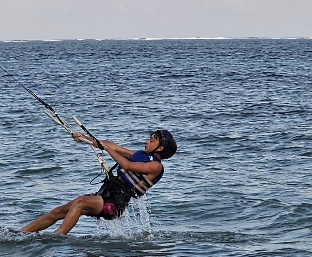 Kitesurfer płynący po wodach Oceanu Indyjskiego przy Diani Beach.