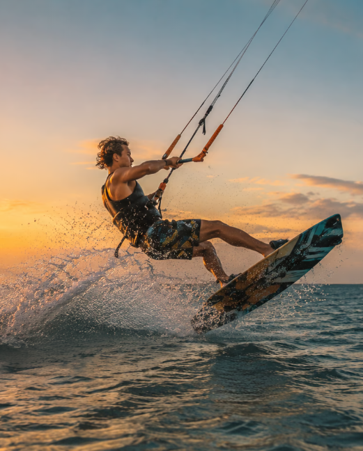 Kitesurfer płynący po Oceanie Indyjskim u wybrzeży Kenii o zachodzie słońca