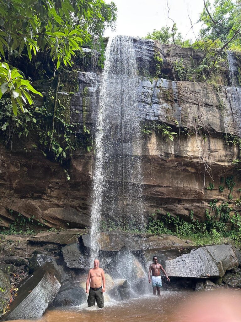 Turyści odpoczywający przy wodospadzie Sheldrick Falls w Shimba Hills.